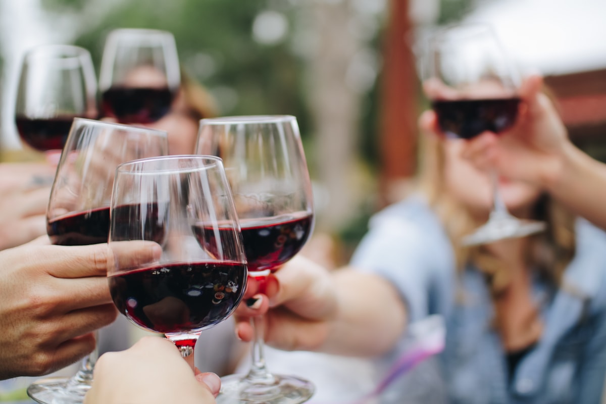Rotwein im Glas bei Abendlicht mit elegantem Dinner-Setting